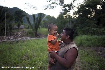 On 15 August 2016 in Belize, 2-year-old Abner laughs while being carried by his father, James Choc, outdoors on their familys plot of land, in San Felipe Village in the Toledo region. The family, which consists of Abners parents, grandparents and aunt  participates in the Roving Caregivers Programme (RCP), which brings services to vulnerable families in the region, especially those living in distant and hard-to-reach locations. Just 50 per cent of villages in the remote, predominately Mayan communities in the Toledo region have access to preschool or day-care services for their children. With many caregivers  including Abners parents and grandfather  working on plantations or construction sites, young children are at risk of missing out on stimulating interaction, a key element for their development. The UNICEF-supported programme, targets children up to age three who have no access to formal early childhood education. RCP facilitators (known as Roving Caregivers or Rovers), who are trained members of the local community, conduct 45-minute home outreach with each of the families they serve, engaging children in age-appropriate stimulating activities through play and encouraging parents and caregivers to participate. They also encourage positive parenting behaviour; and promote behaviour change to address inappropriate parenting practices The 22 Rovers in the RCP programme conduct 45-minute outreach visits with each family. My favourite part of my childrens lives was when they were young and playing without worry; they were laughing and smiling and growing, said Abners grandmother, Maria Choc (not pictured), a mother of 13. In recent years, considerable progress was made in the area of Early Childhood Development. In 2011 only 32 per cent of children between 36 and 59 months of age attended an Early Childhood Education (ECE) programme, but this reached 55 per cent by 2015. Disparities however persist as only one in five of the p