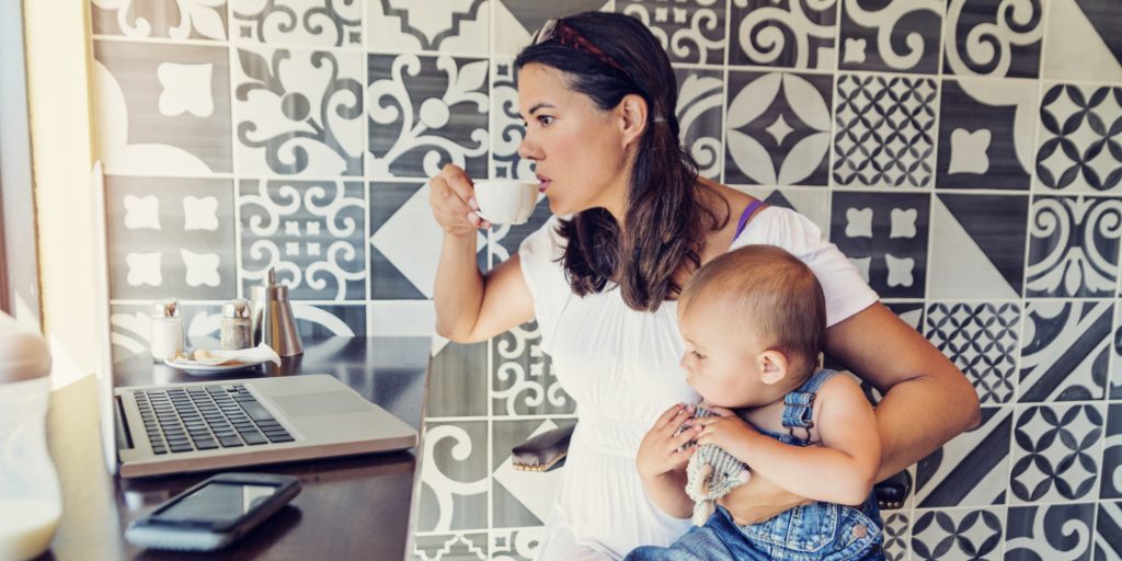 Urban mom balancing work and family in a public cafe.